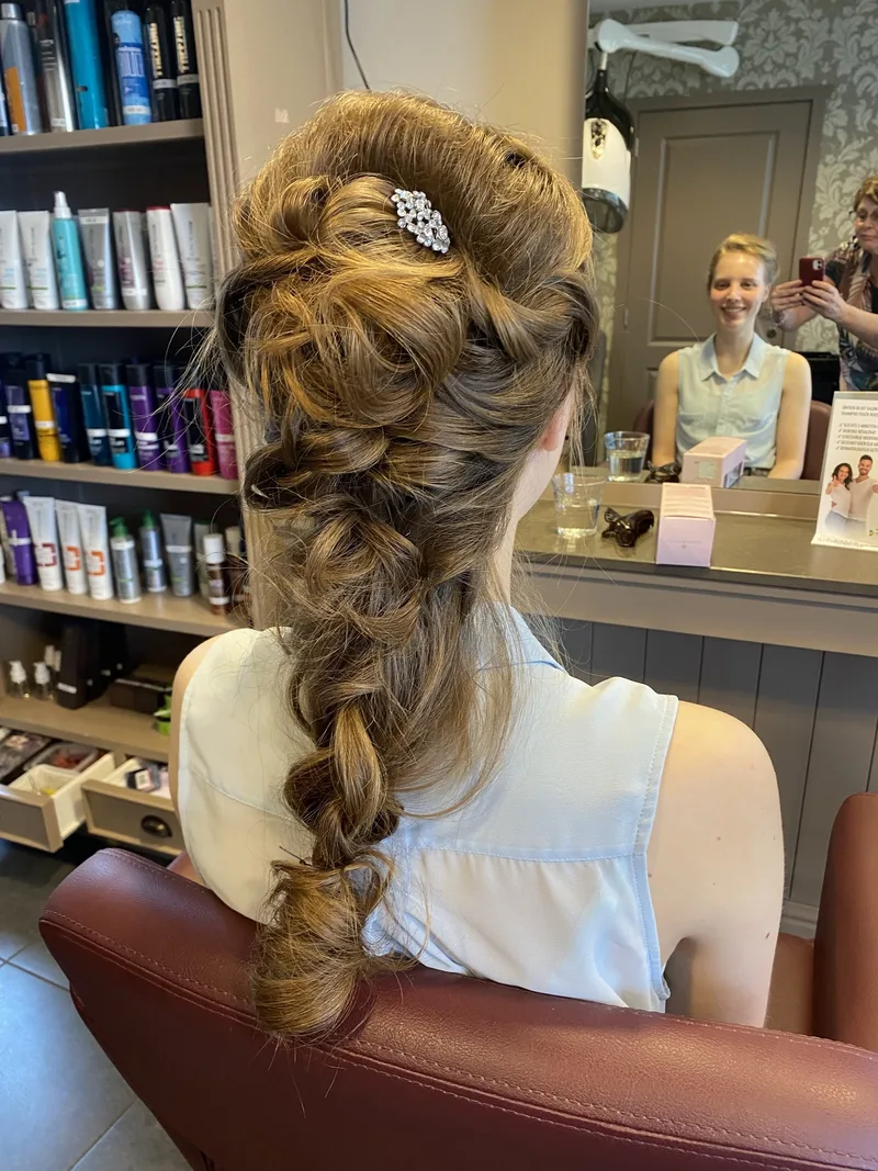 Gevlochten kapsel met grote lussen en een haaraccessoire met strass