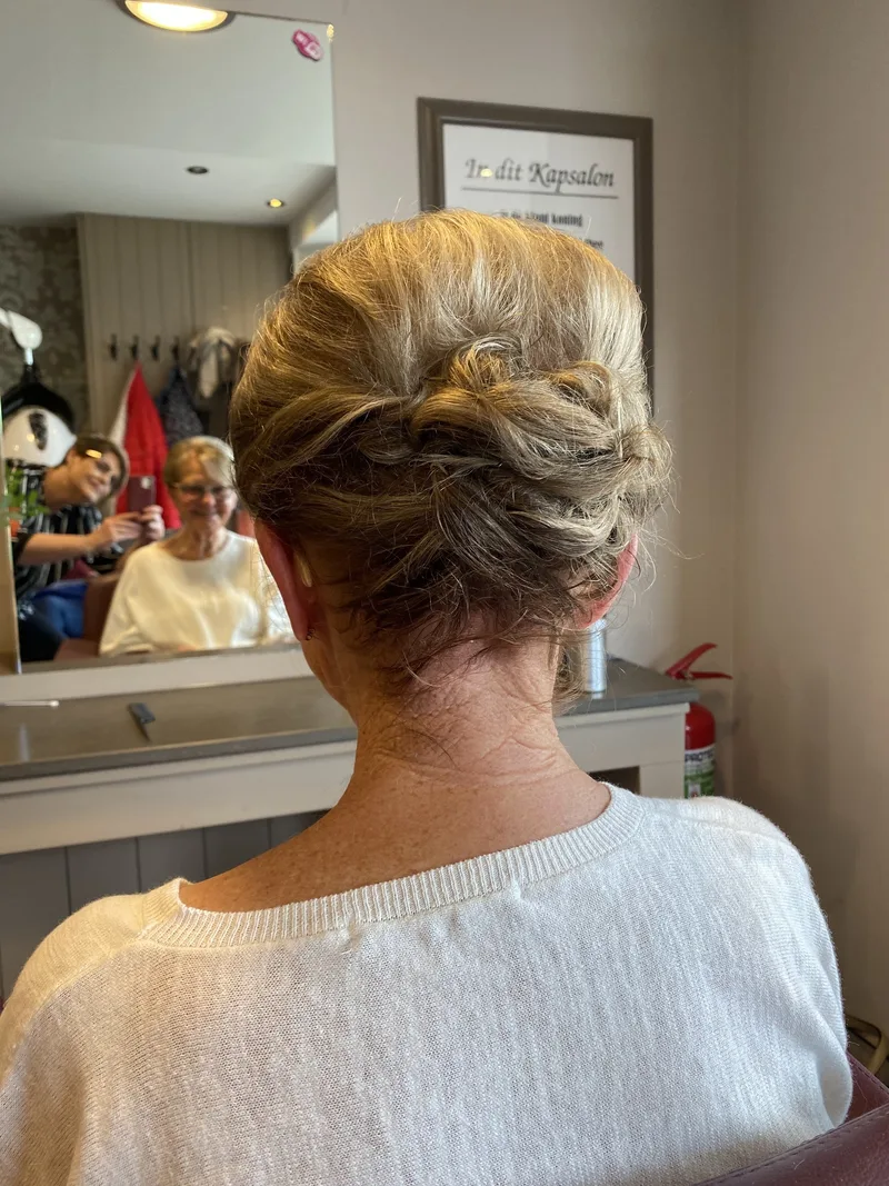 Gedraaid opsteekkapsel in blond en grijs haar met spiegelbeeld op de achtergrond
